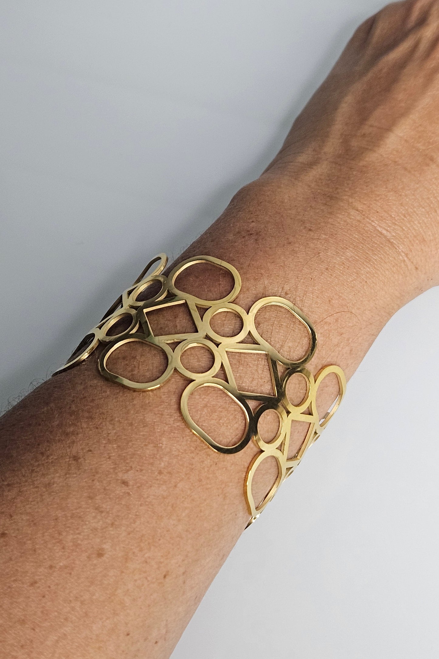 BANGLE DORADO CON DIFERENTES FIGURAS GEOMÉTRICAS