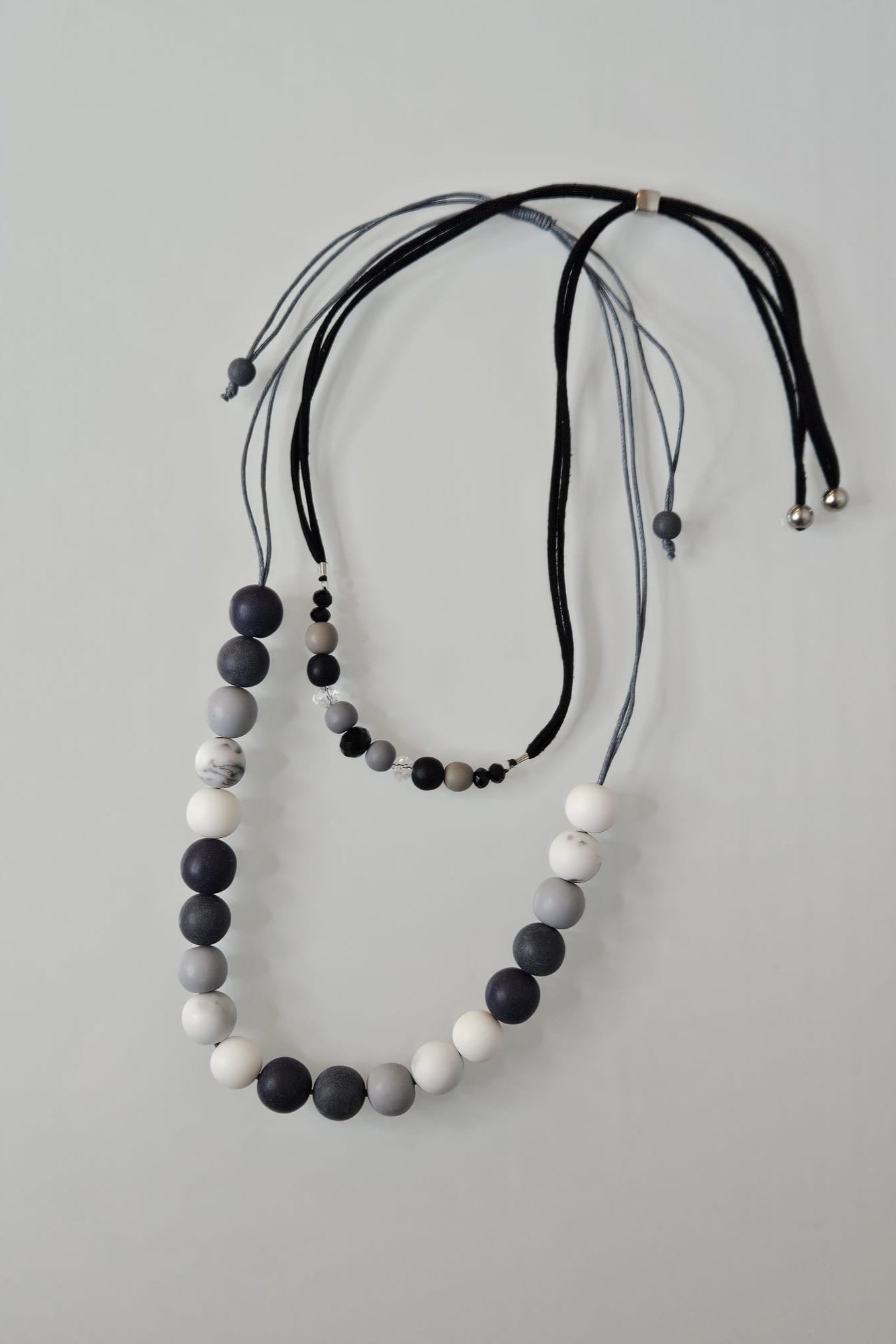 COLLAR EN LAYERS CON ESFERAS GRISES, BLANCAS Y NEGRAS