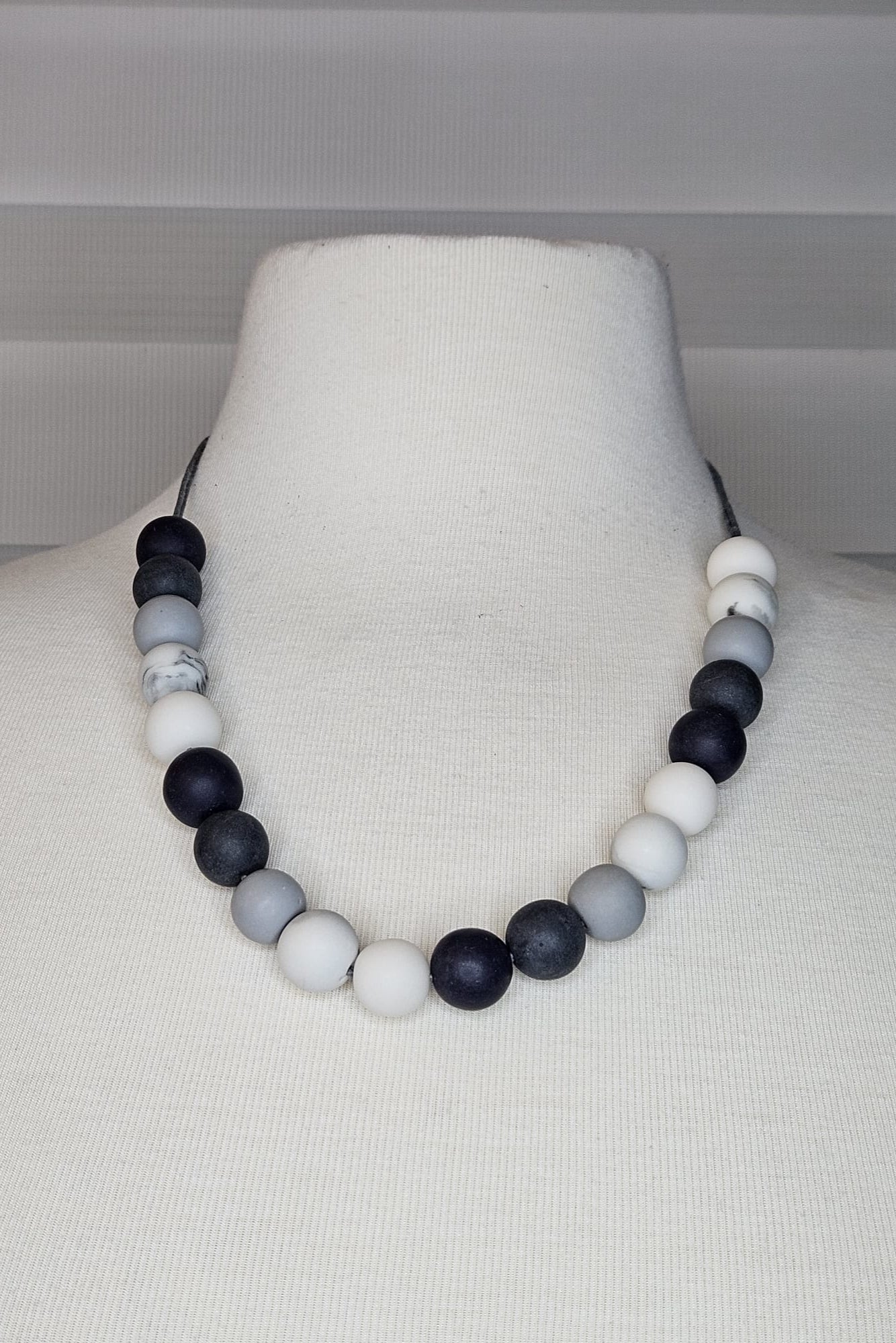 COLLAR EN LAYERS CON ESFERAS GRISES, BLANCAS Y NEGRAS