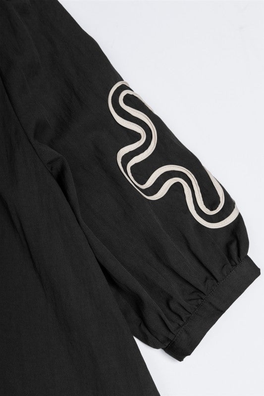 BLUSA NEGRA CON APLIQUES ABSTRACTOS Y MANGAS 3/4