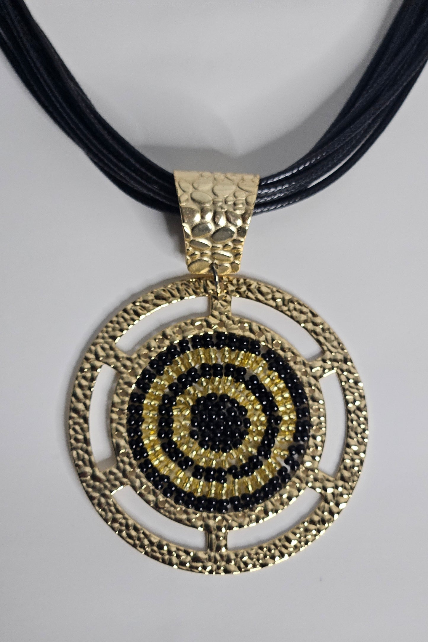 COLLAR NEGRO EN PIEL CON PENDANT REDONDO DORADO Y NEGRO