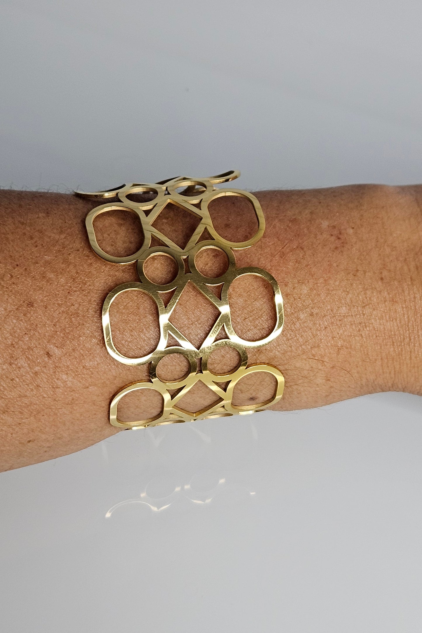BANGLE DORADO CON DIFERENTES FIGURAS GEOMÉTRICAS