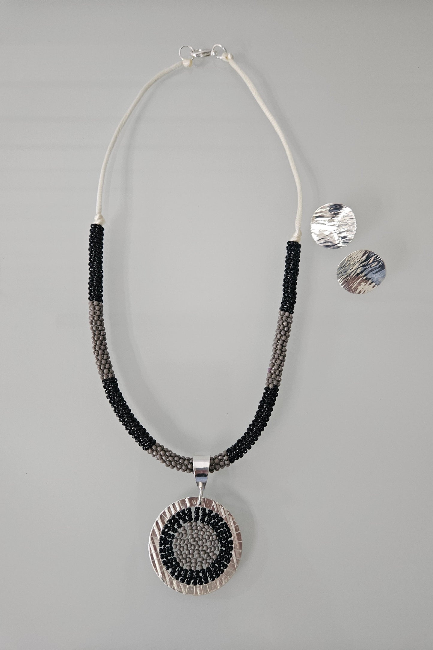 SET DE COLLAR NEGRO Y GRIS CON PENDANT REDONDO PLATEADO Y PANTALLAS