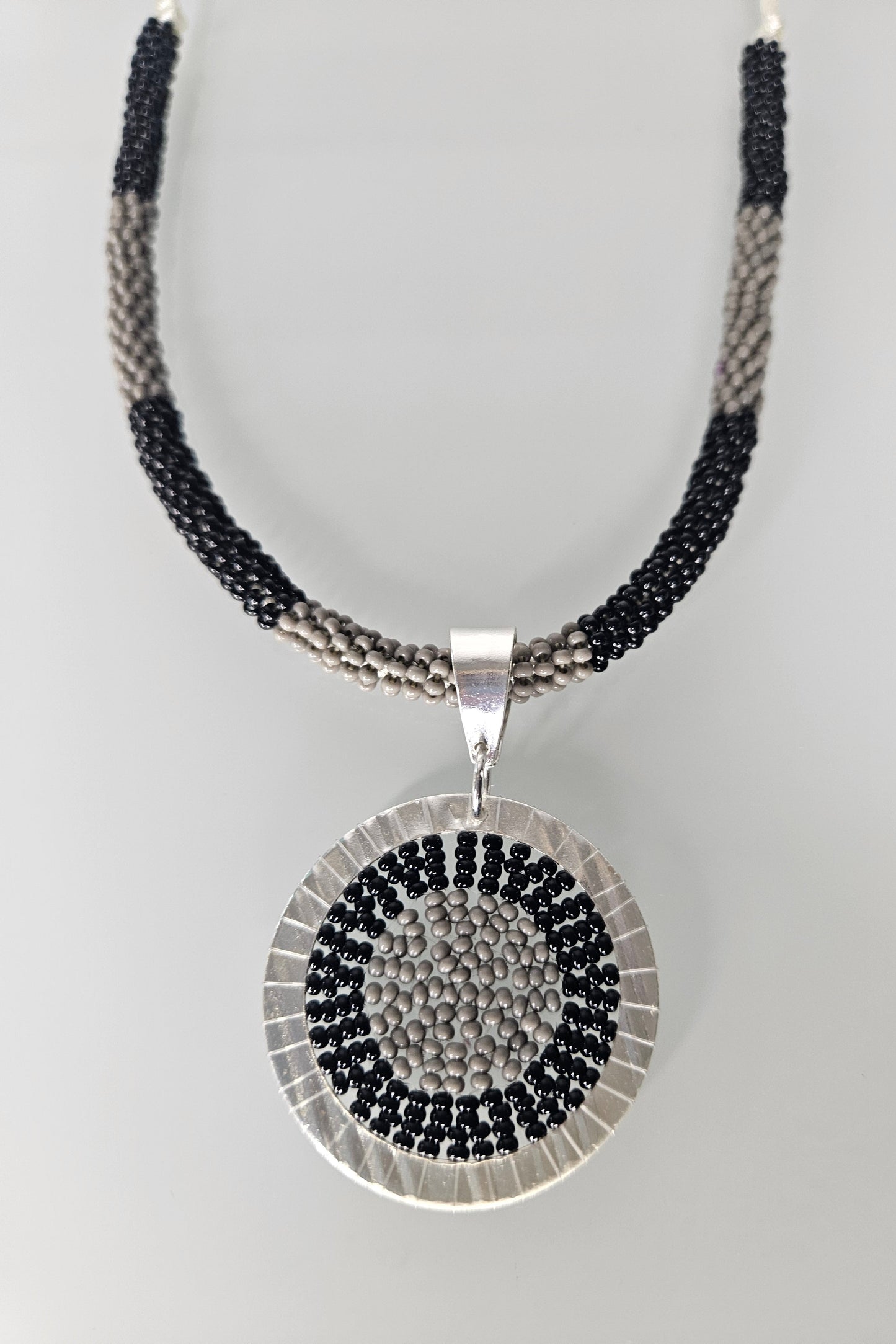 SET DE COLLAR NEGRO Y GRIS CON PENDANT REDONDO PLATEADO Y PANTALLAS