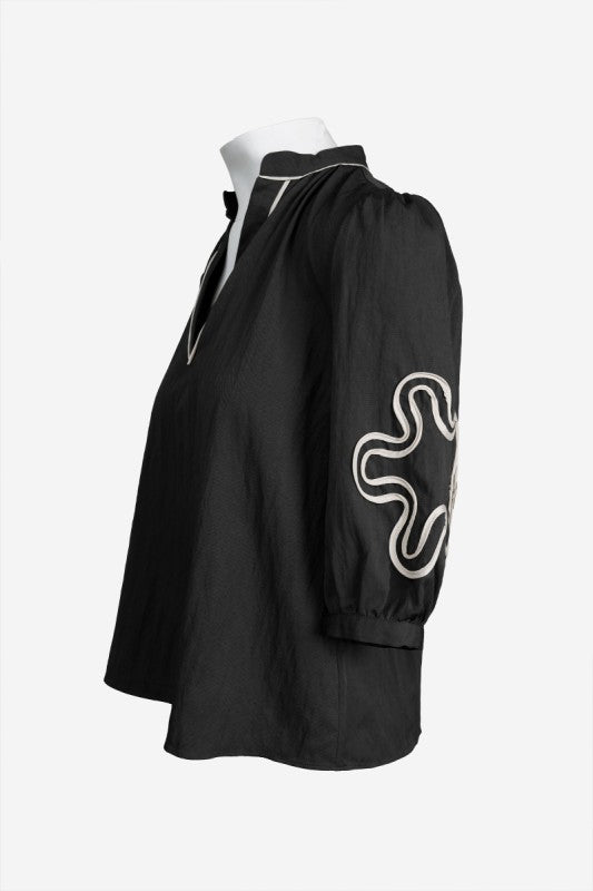BLUSA NEGRA CON APLIQUES ABSTRACTOS Y MANGAS 3/4