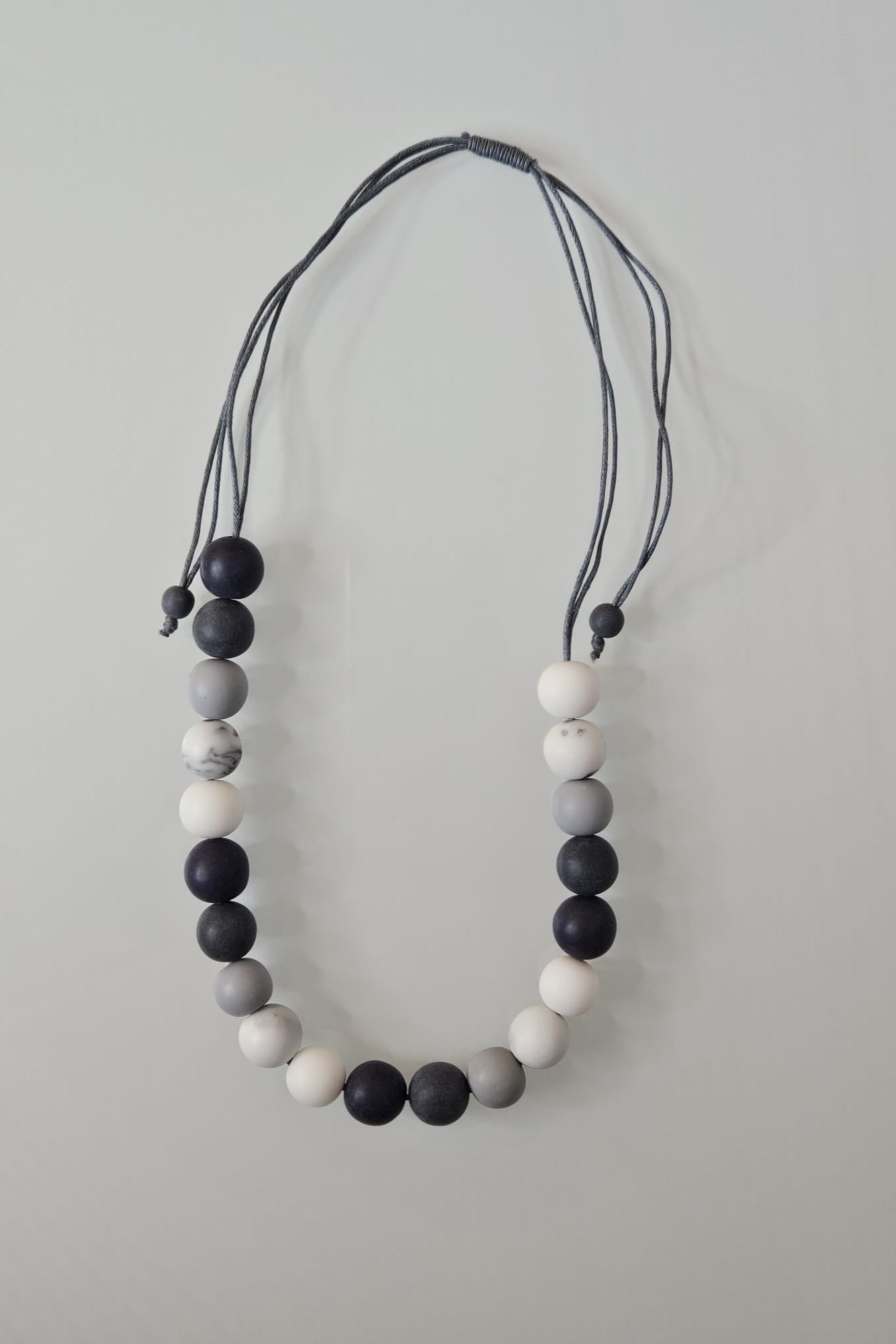 COLLAR EN LAYERS CON ESFERAS GRISES, BLANCAS Y NEGRAS