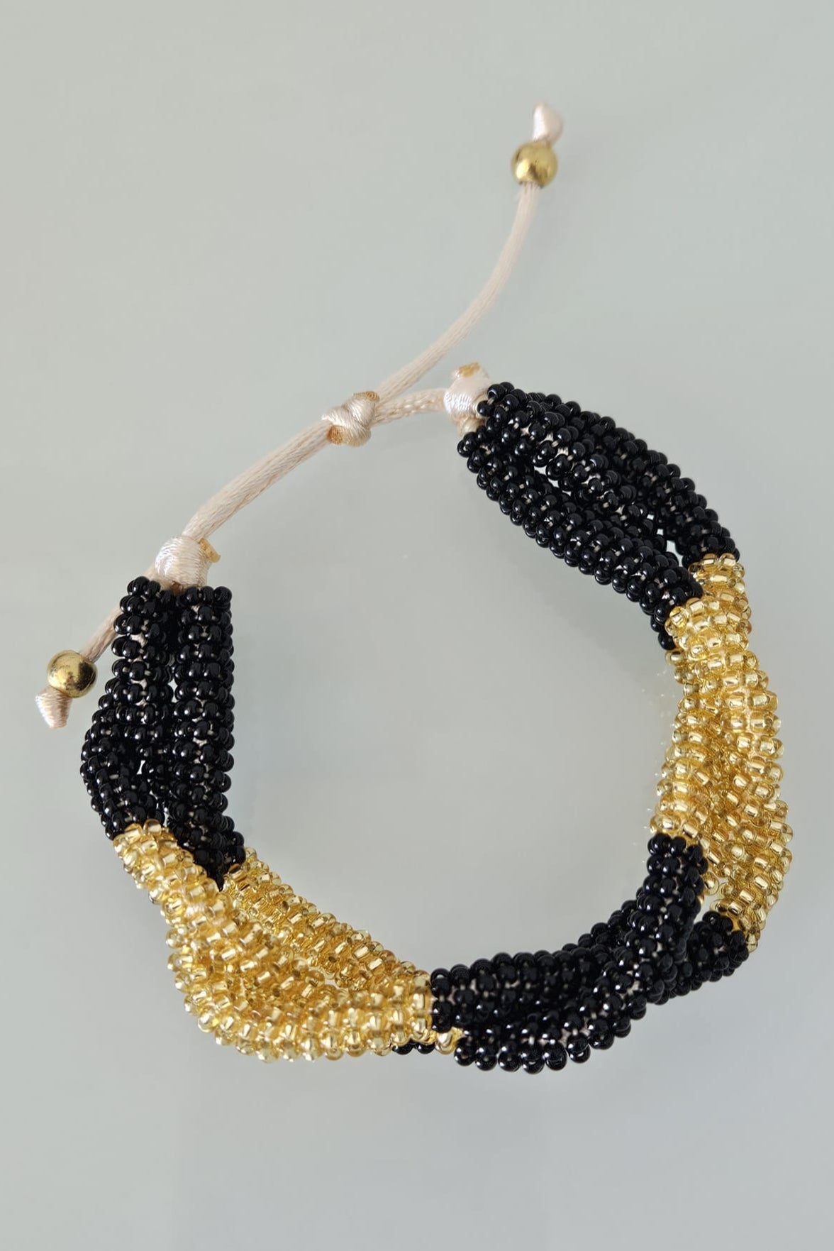 SET DE PULSERA TRENZADA Y ARETES NEGRO Y DORADO