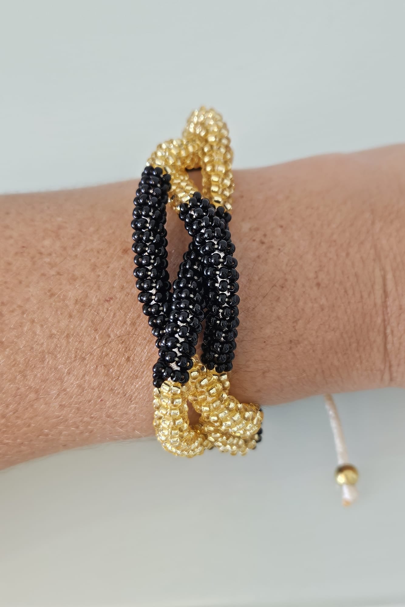 SET DE PULSERA TRENZADA Y ARETES NEGRO Y DORADO