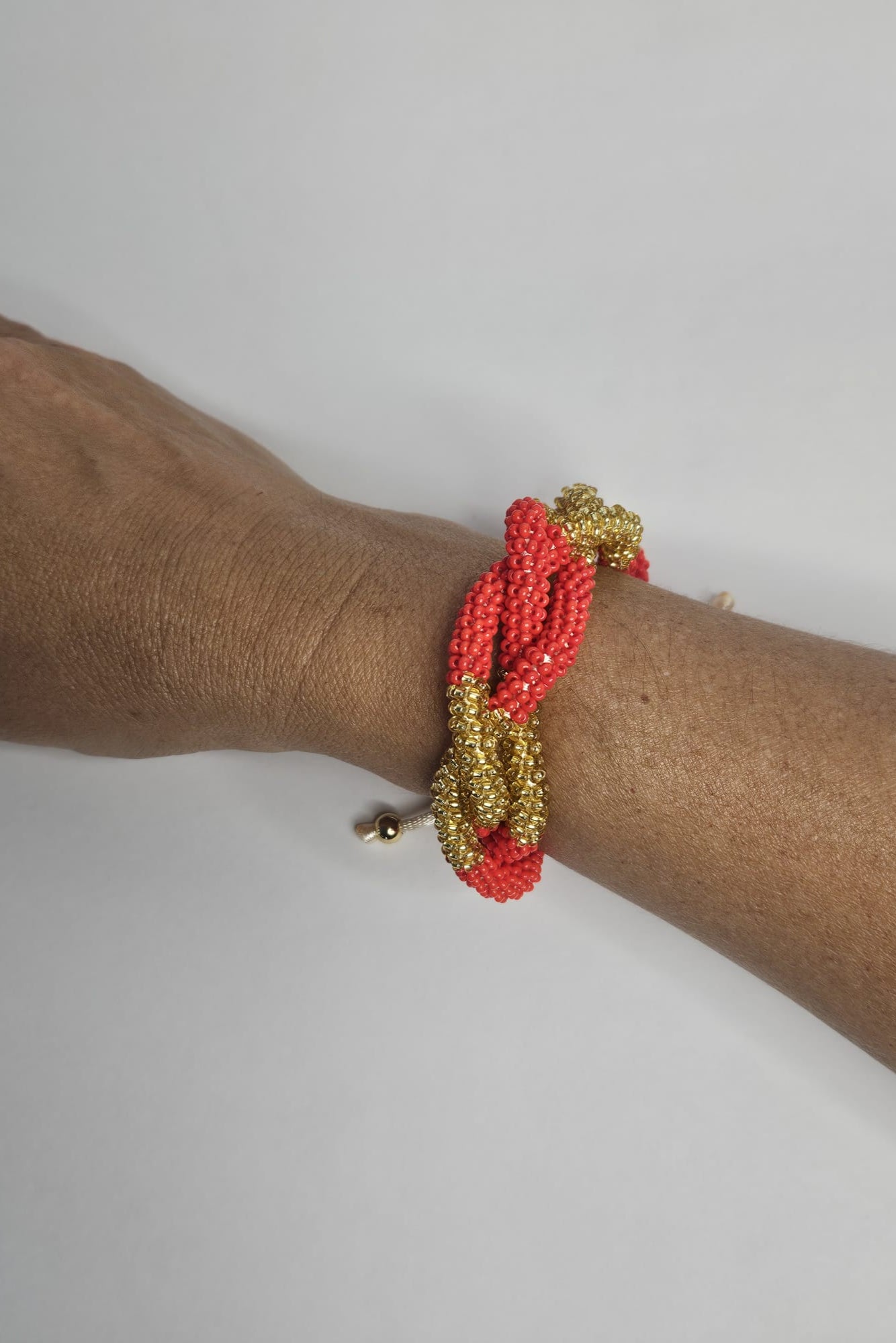 SET DE PULSERA TRENZADA Y ARETES DORADO Y ROJO