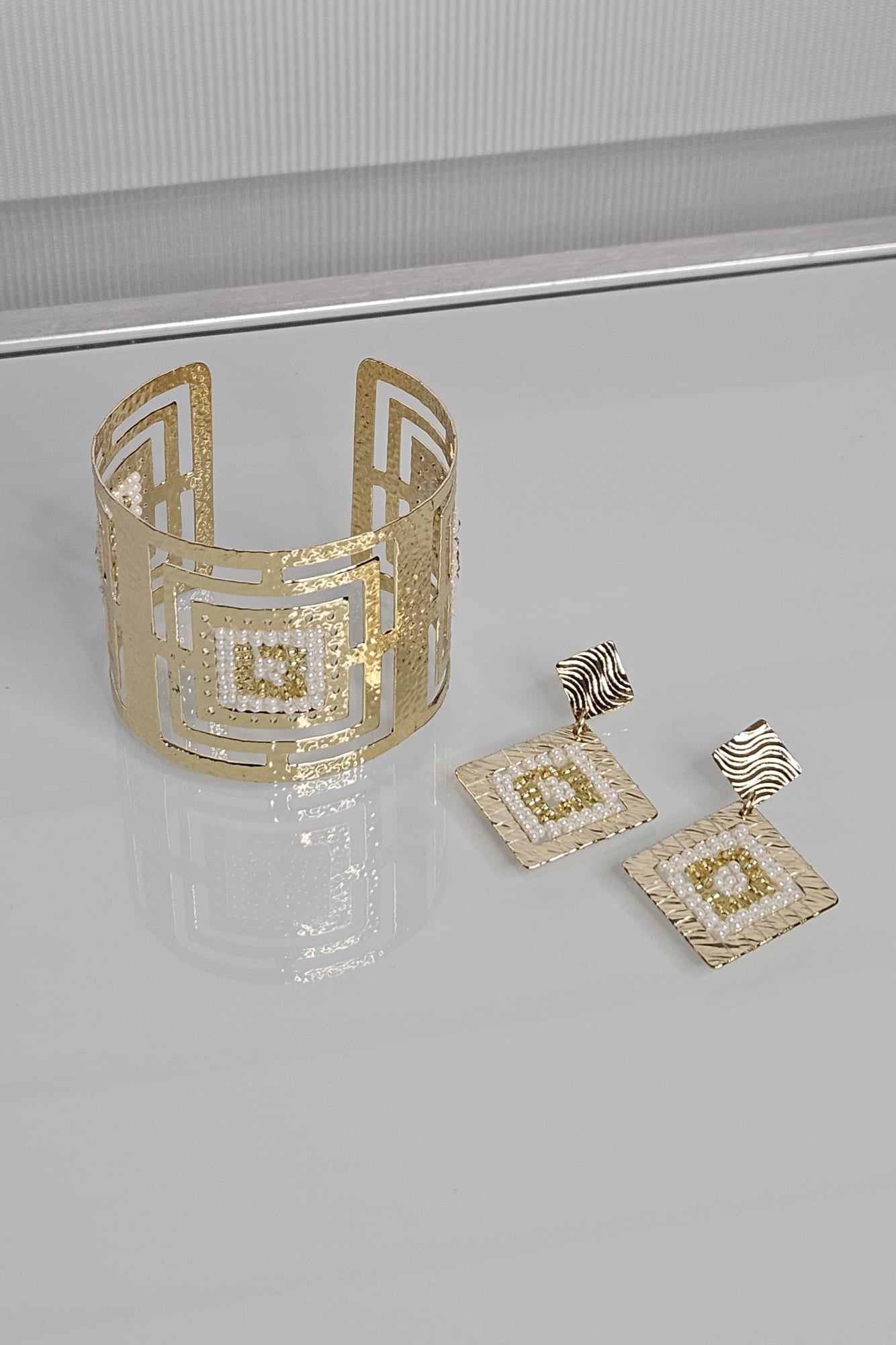 SET DE BRAZALETE Y ARETES DORADO Y BLANCO.