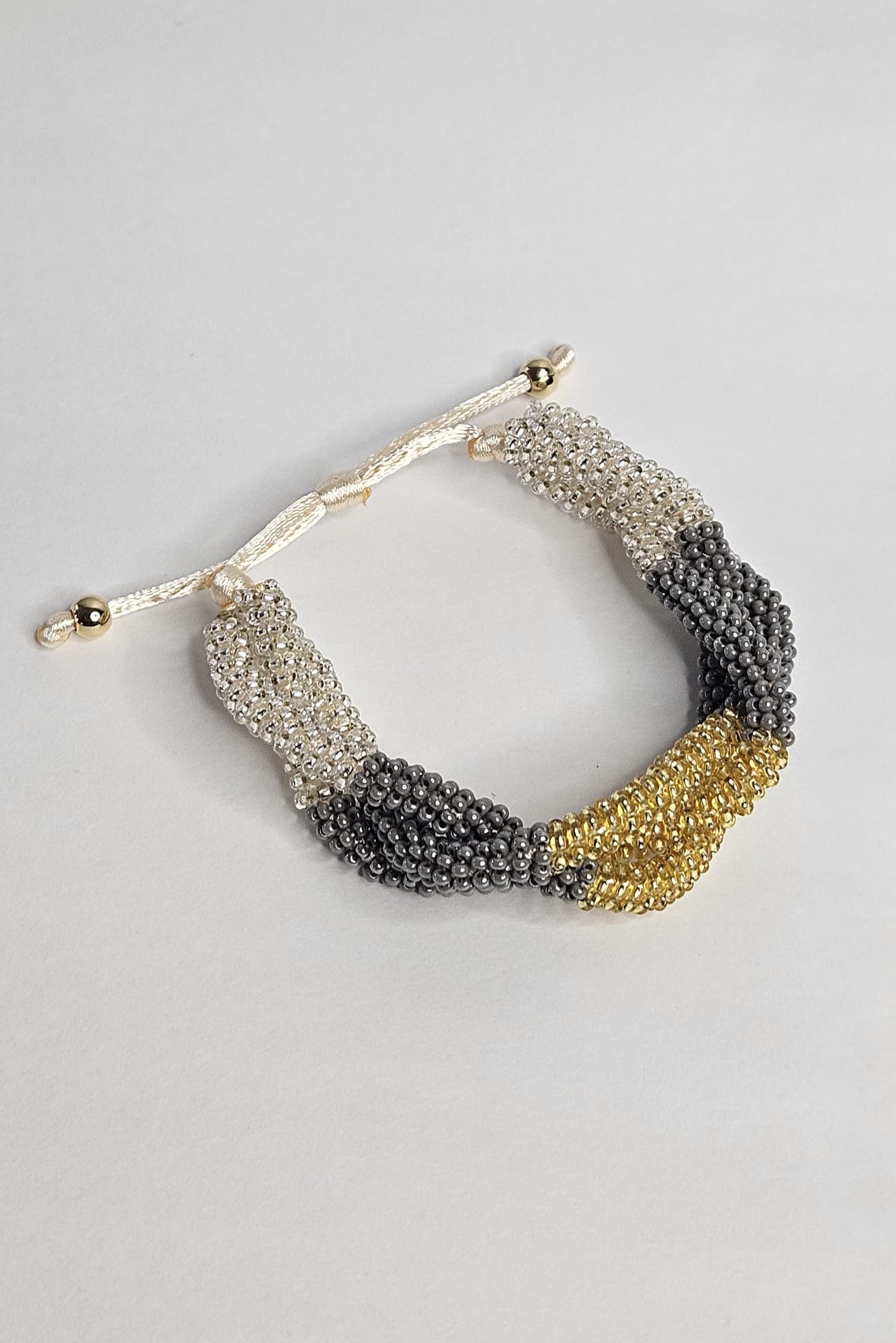 SET DE PULSERA TRENZADA Y ARETES DORADO, GRIS Y TRANSPARENTE