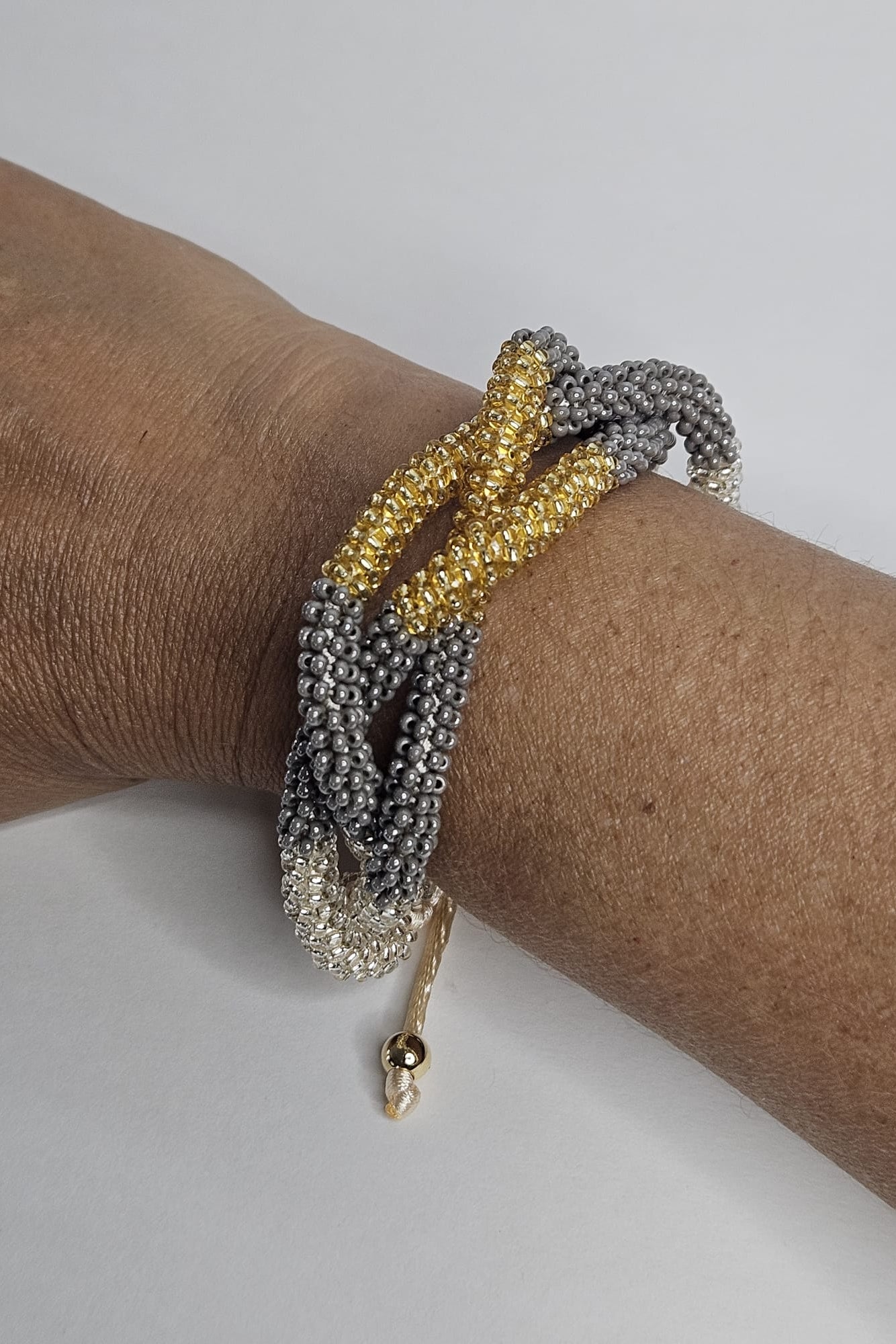 SET DE PULSERA TRENZADA Y ARETES DORADO, GRIS Y TRANSPARENTE