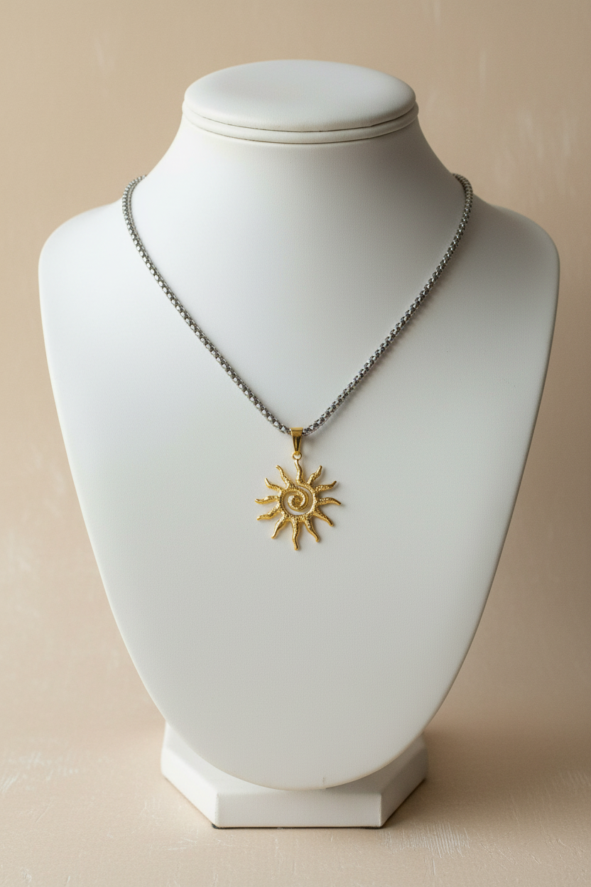 Cadena plateada con dije de sol dorado en display blanco