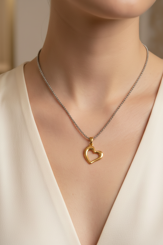Close-up de cadena con dije de corazón dorado en cuello de modelo