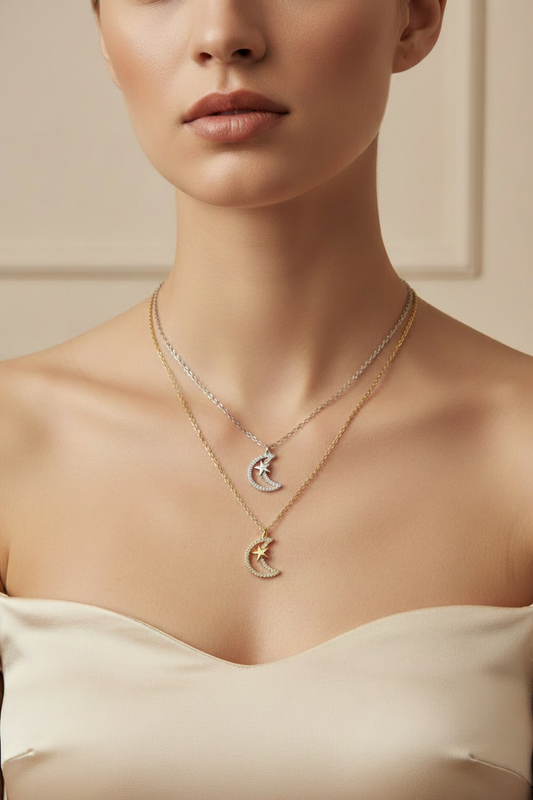 Close-up de cadenas con dijes de luna y estrella en capas en cuello de modelo