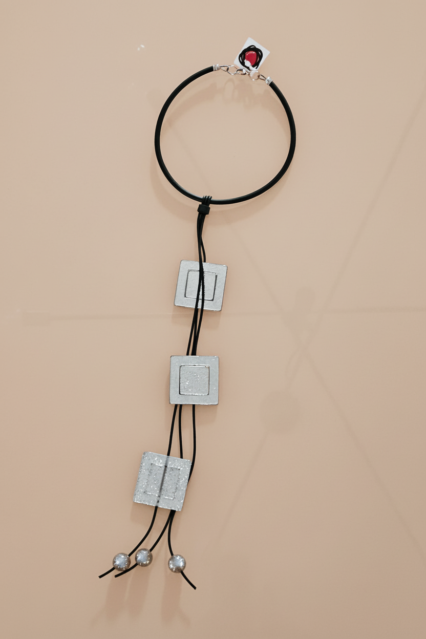 Collar plateado cuadros flat lay fondo nude