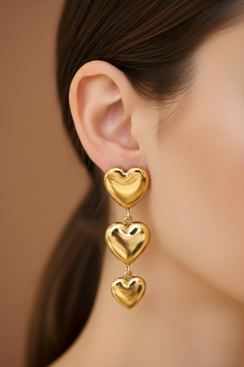 Primer plano de oreja con pantallas de 3 corazones dorados